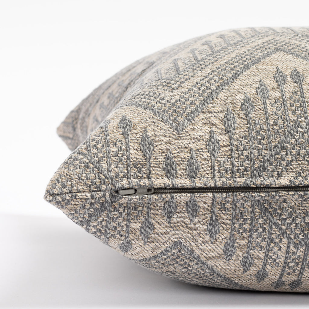 a grey and denim blue intricate zig zag patterned throw pillow : close up zipper view