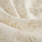 Close up of Tonic Living Juniper Parchment fabric showing its linen-blend texture and botanical sprig detail.