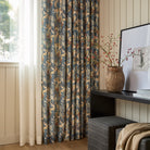 Juno Navy drapery fabric by Tonic Living — linen-blend drapery fabric with a painterly botanical floral pattern in navy and earthy tones, shown as curtains styled in a living room.