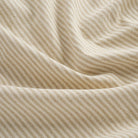 Close up of Tonic Living Leo Stripe Wheat fabric showing wheat and natural vertical stripe detail.
