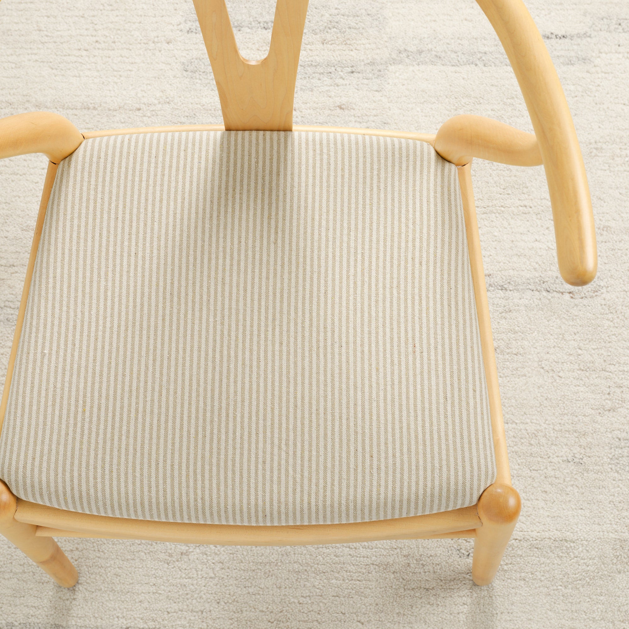Tonic Living Leo Stripe Wheat upholstery fabric shown on a dining chair seat with a classic stripe design.