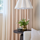 Lyra Fabric, Blush by Tonic Living — shown as floral block print drapery behind a chair styled with the Lyra 14x20 Lumbar Pillow, Blush Pink.