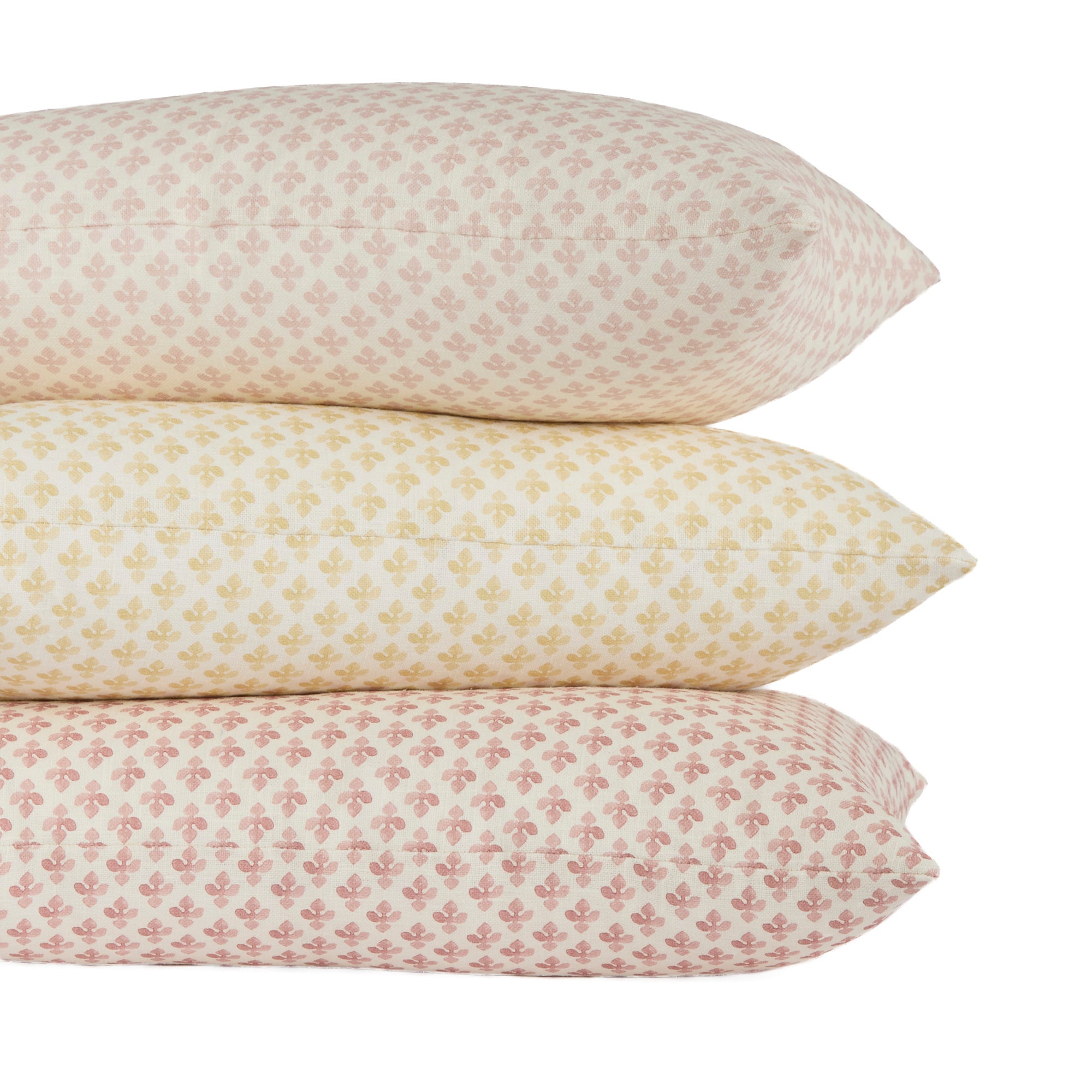 Stack of Lyra lumbar pillows in Blush, Butter Yellow, and Berry by Tonic Living — floral block print designs in soft romantic tones.