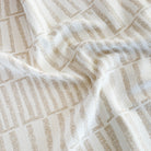 a beige and white abstract geometric patterned upholstery fabric