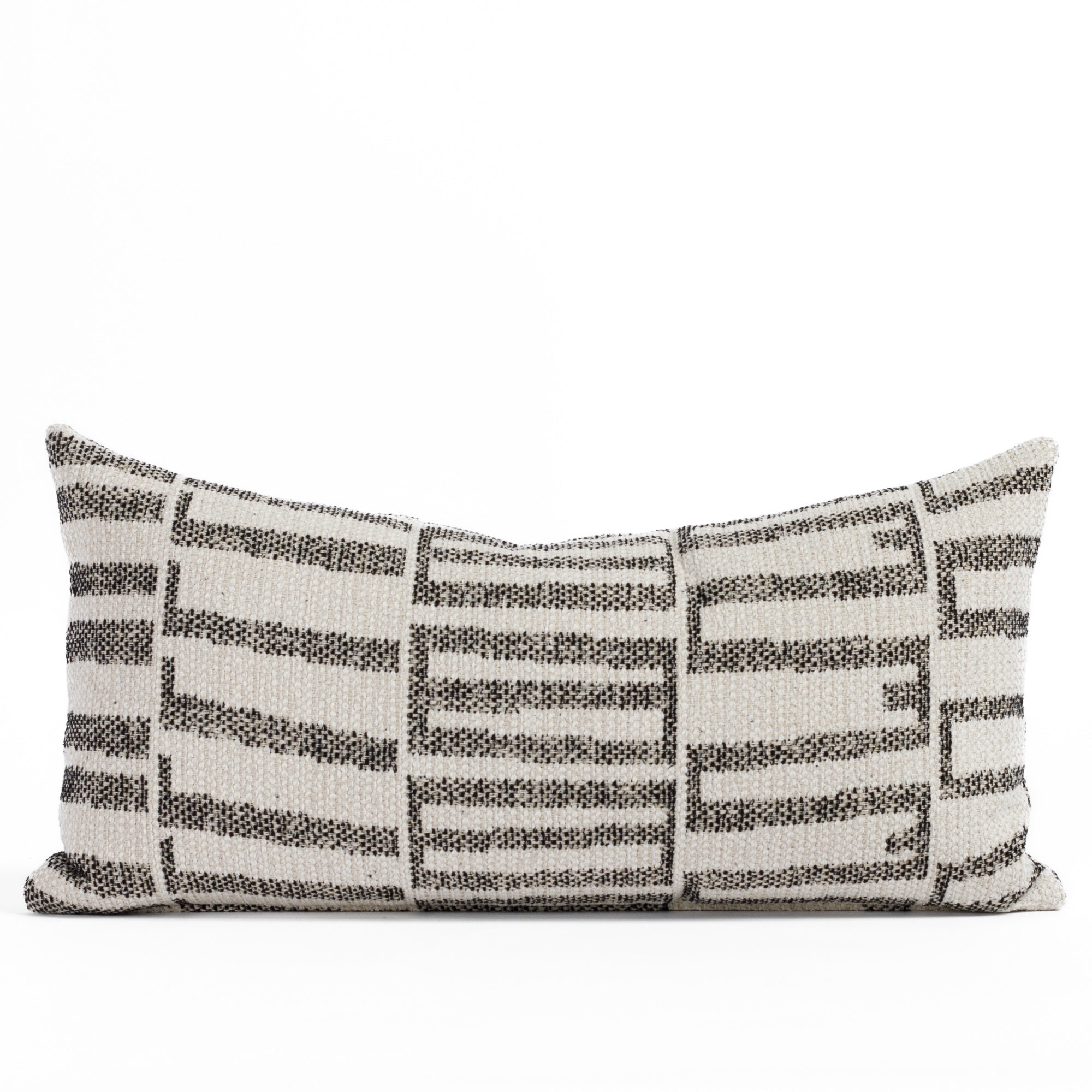 Front view of Tonic Living’s Mallia 12x24 outdoor lumbar pillow in Carbon, featuring a bold black and sandy beige geometric pattern on high-performance, fade-resistant fabric.