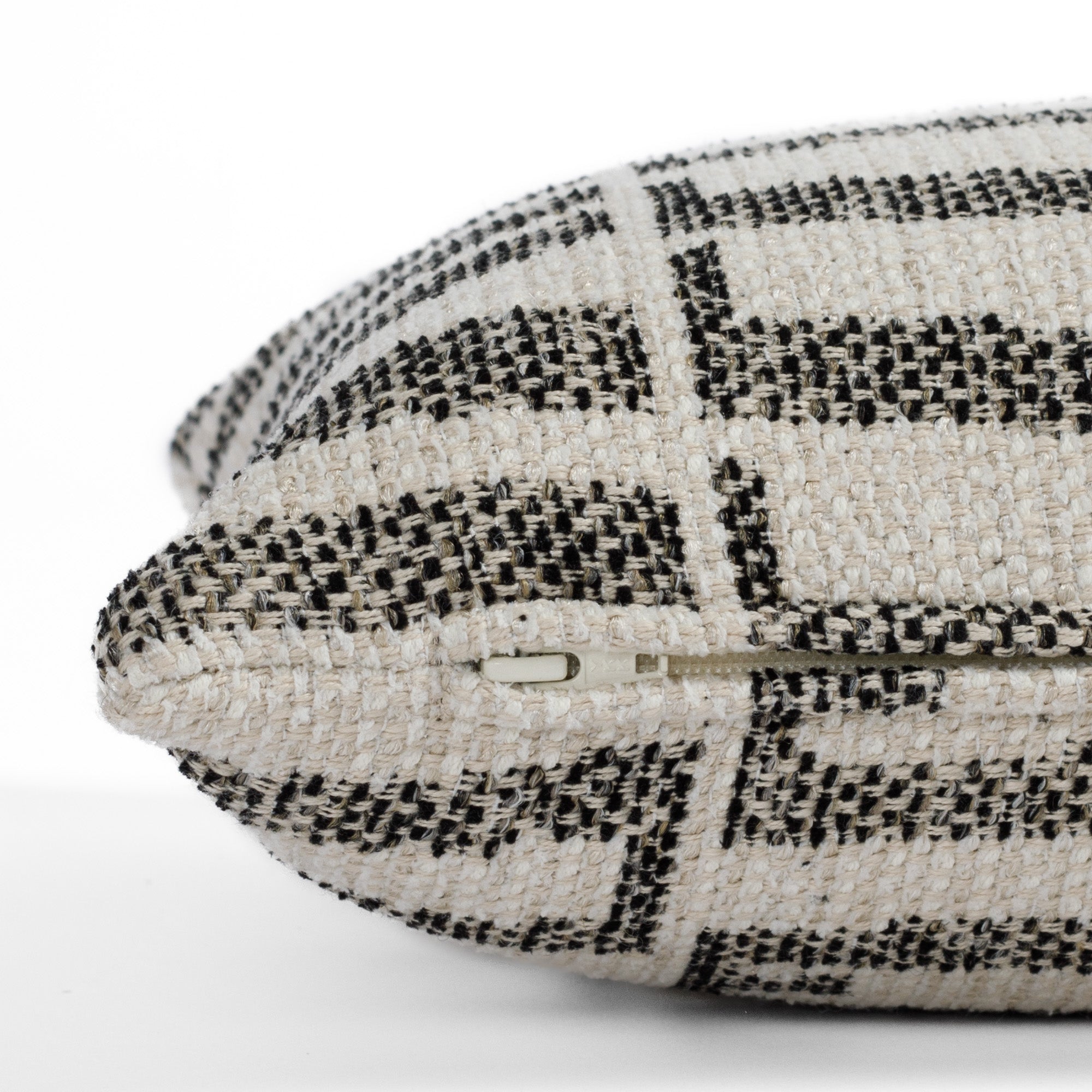 Side detail of Tonic Living’s Mallia 12x24 lumbar toss pillow, highlighting the discreet zipper and durable InsideOut® outdoor fabric in a black and neutral palette.