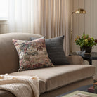 A pair of Tonic Living's vintage patterned throw pillows styled on a brown velvet sofa.