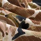 Close up of Tonic Living Marbella Inkwell fabric showing its abstract floral pattern in brown, navy blue, beige, and blush pink.
