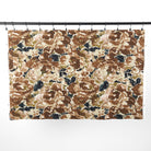 Full yard of Tonic Living Marbella Fabric in Inkwell hanging to show the scale and drape of its brown and blue abstract floral pattern.