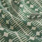 Close up of Tonic Living Meadow Emerald fabric showing its spruce green block print detail and texture.