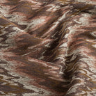 Tonic Living Mendoza Fig upholstery fabric with an abstract flamestitch pattern in earthy plum and brown.