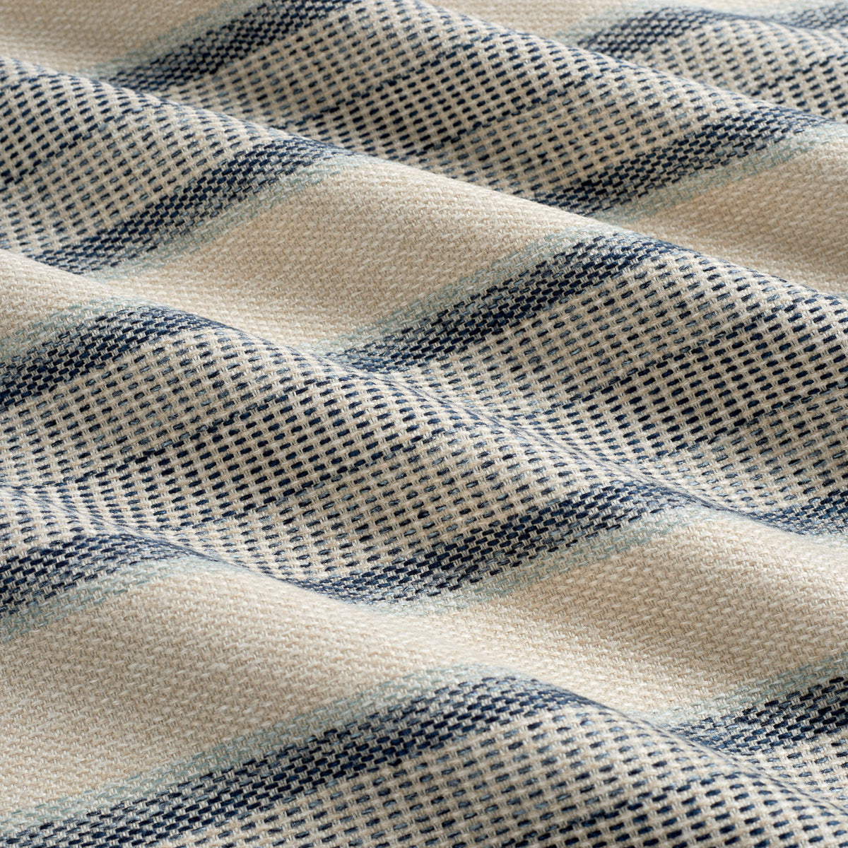 Tonic Living Miller Stripe Denim performance upholstery fabric featuring varied banded stripes in faded denim blue and sandy beige.