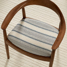 Tonic Living Miller Stripe Denim high-performance fabric shown upholstered on a dining chair seat with soft blue stripes.