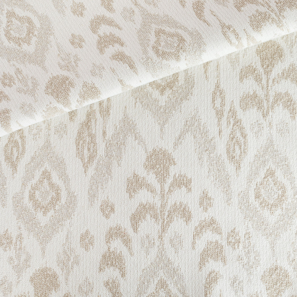 a cream, white and taupe oversized ikat patterned, chenille textured indoor outdoor upholstery fabric