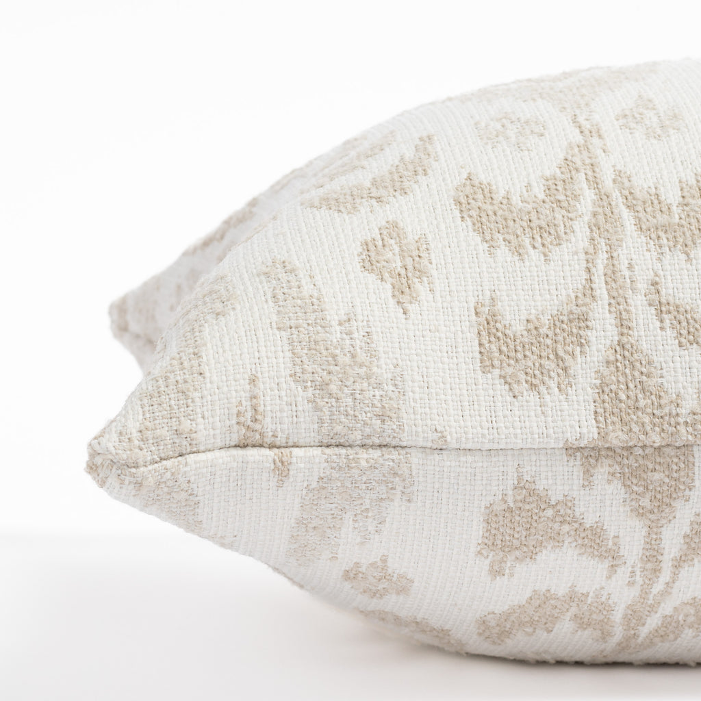 a white, cream and taupe large scale ikat patterned, chenille textured bolster pillow : close up side view