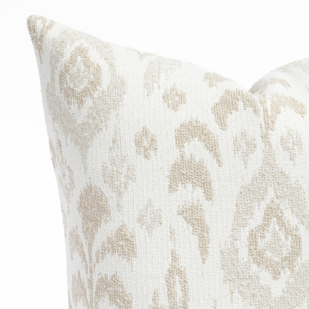 a white, cream and taupe large scale botanical ikat patterned outdoor pillow : close up view