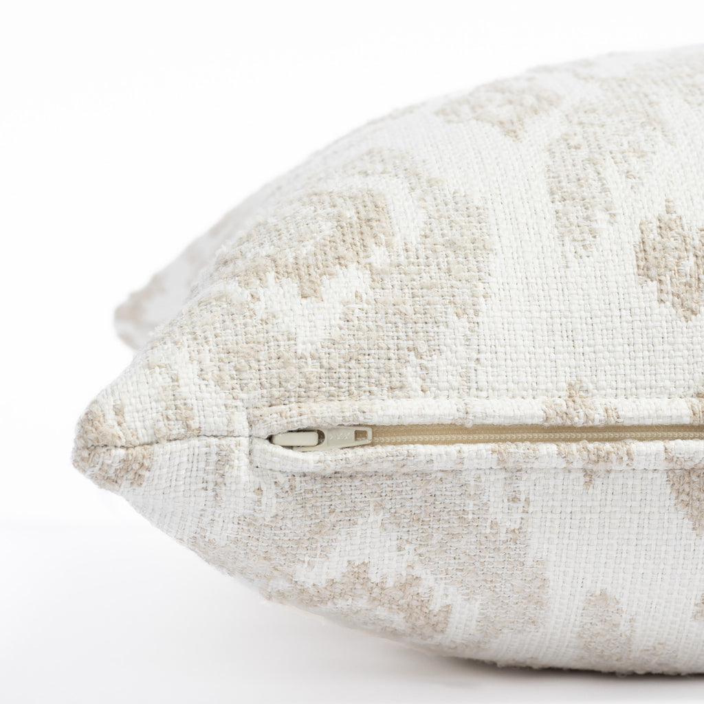 a white, cream and taupe large scale botanical ikat patterned outdoor pillow : close up zipper view