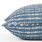 Close-up zipper side view of a denim blue and white pillow with piped detail and dotted stripe pattern (Nile Indigo from Tonic Living).