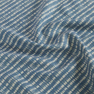 Tonic Living Nile Fabric in Indigo showcasing a blue and white shibori-style stripe design.
