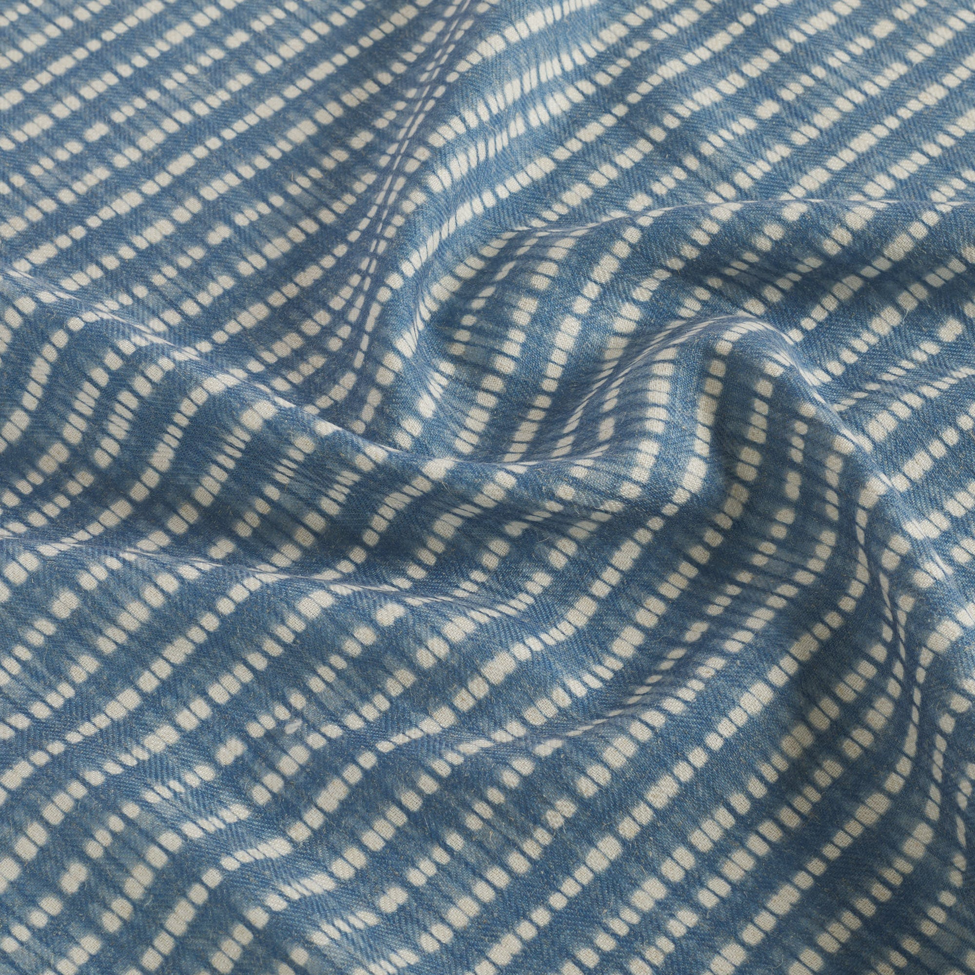 Tonic Living Nile Fabric in Indigo showcasing a blue and white shibori-style stripe design.