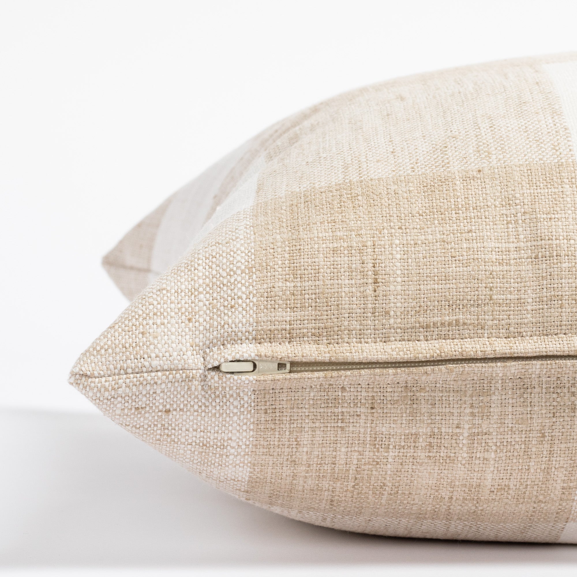 a white and beige check patterned throw pillow : zipper view