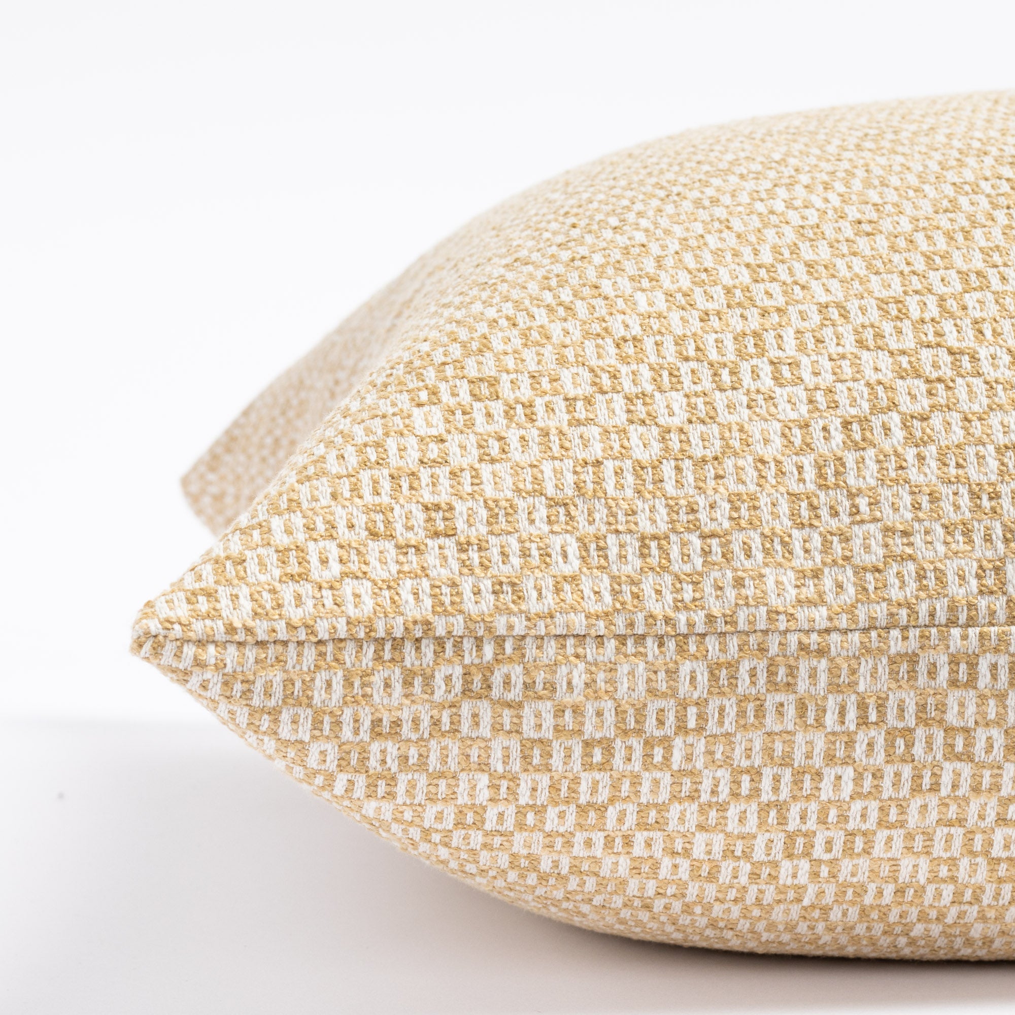 a yellow gold and cream small check patterned throw pillow : close up side view