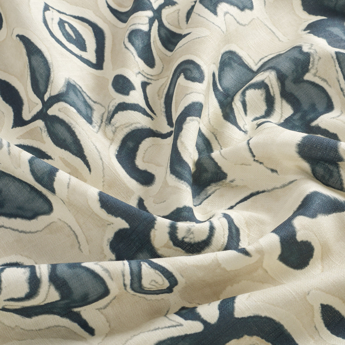 Tonic Living Paloma Ink drapery fabric featuring bold inky blue blooms and scrolling leaves on a neutral oatmeal background.