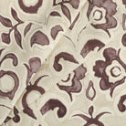 Tonic Living Paloma Mauve drapery fabric featuring bold muted purple blooms and scrolling leaves on a neutral oatmeal background.