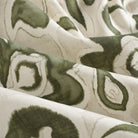 Close up of Tonic Living Paloma Olive drapery fabric showing stylized olive green flowers and scrolling leaves with a watercolour effect.