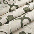 Tonic Living Paloma Olive floral fabric shown as a Roman shade, featuring a stylized olive green botanical pattern on oatmeal beige.