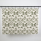 Full yard of Tonic Living Paloma Fabric in Olive hanging to show the scale and drape of its olive green floral pattern.