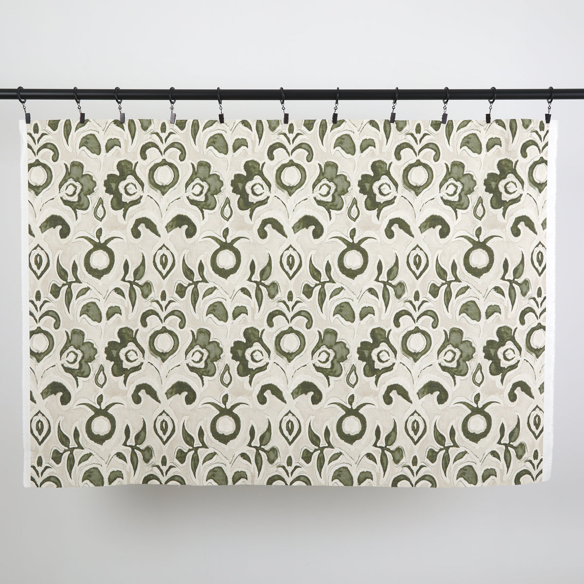 Full yard of Tonic Living Paloma Fabric in Olive hanging to show the scale and drape of its olive green floral pattern.