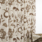 Tonic Living Paloma Walnut floral drapery fabric shown as curtains featuring a painterly warm brown botanical pattern on oatmeal beige.