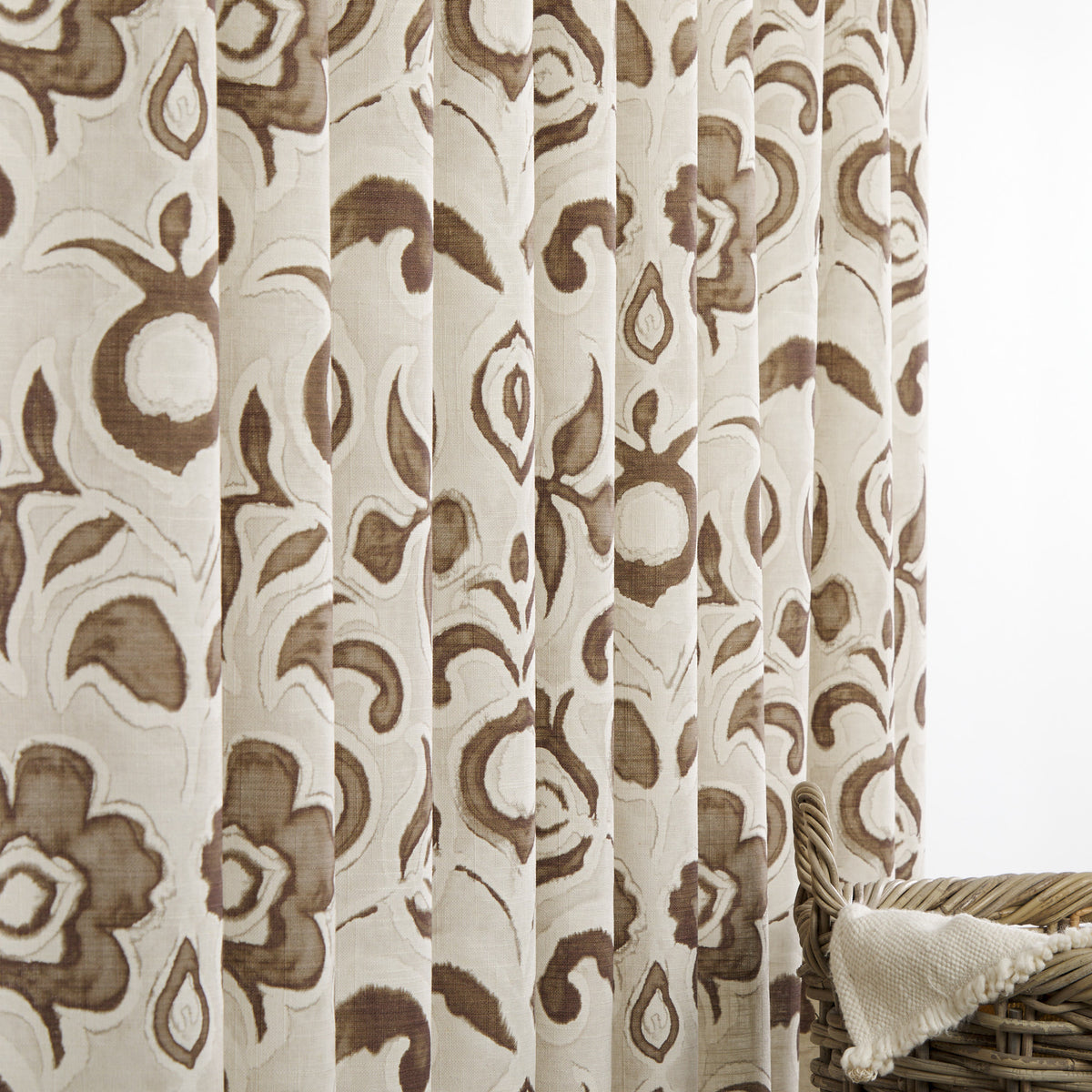 Tonic Living Paloma Walnut floral drapery fabric shown as curtains featuring a painterly warm brown botanical pattern on oatmeal beige.