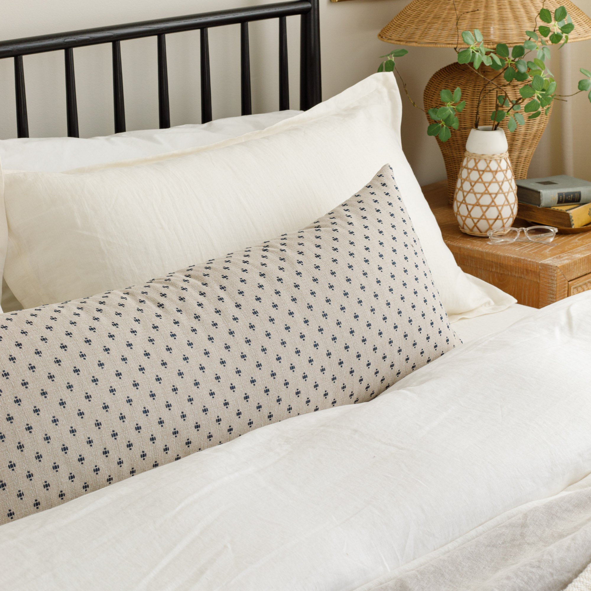 Pierce Navy 16x42 Bolster Pillow, a preppy navy blue and taupe pillow from Tonic Living, styled in a bedroom. 