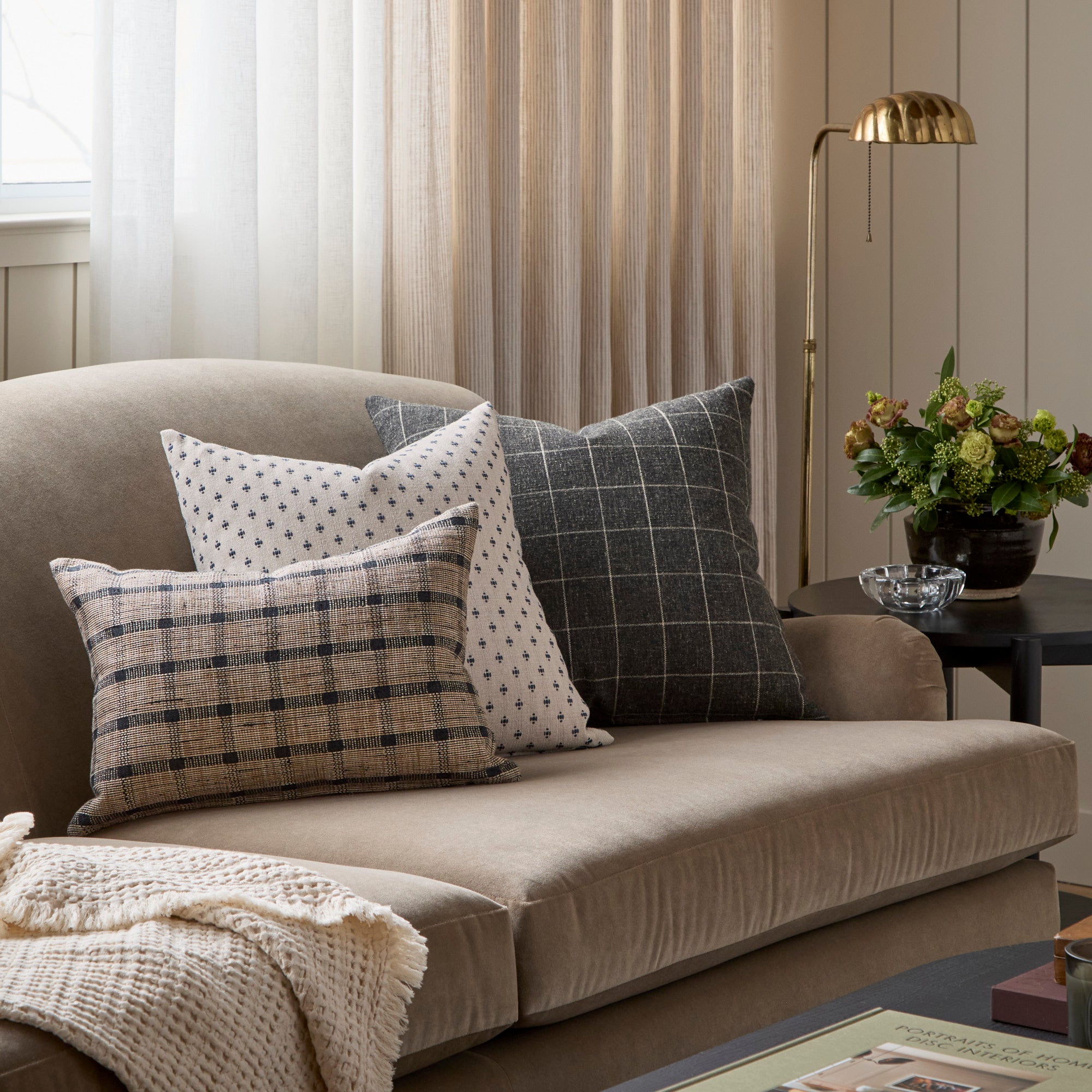 Three neutral patterned toss cushions from Tonic Living, styled on a sofa.