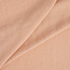 Tonic Living Pietra Salmon Pink double-width linen fabric with a lightweight drape and subtle slub texture.