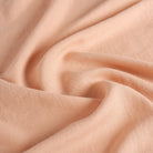 Tonic Living Pietra Salmon Pink 100% linen drapery fabric featuring a soft woven texture and relaxed look.