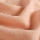 Close up of Tonic Living Pietra Salmon Pink fabric showing soft salmon linen weave and natural slub texture.