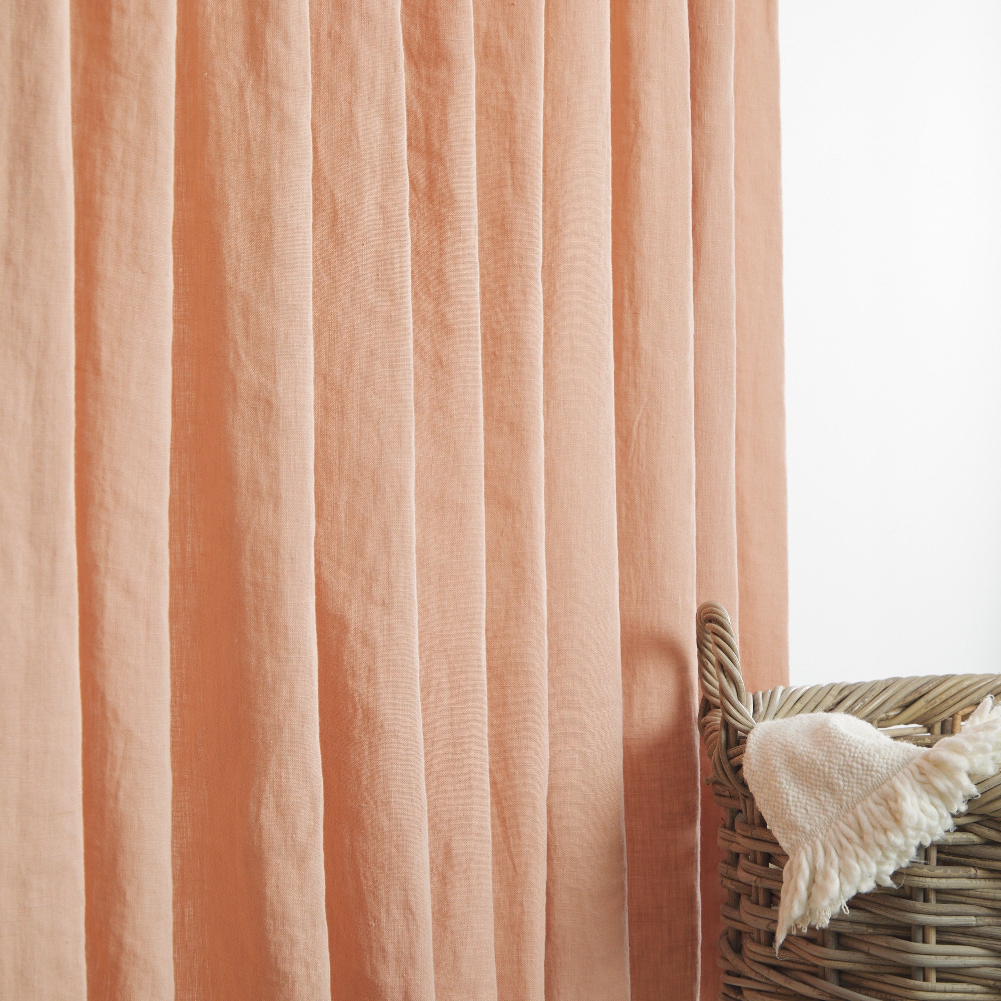 Tonic Living Pietra Salmon Pink curtain fabric shown as linen drapery in a soft salmon colour.