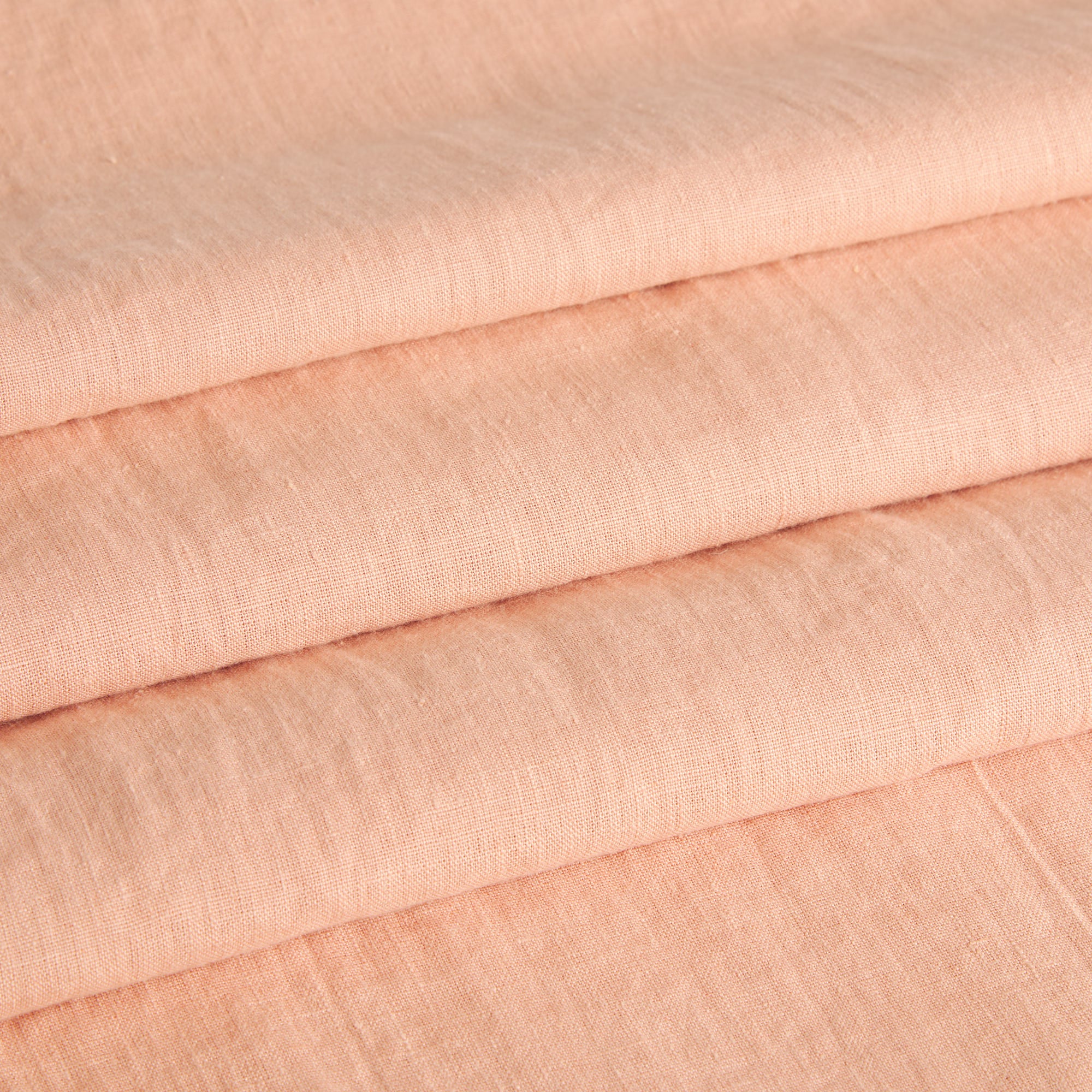 Tonic Living Pietra Salmon Pink linen fabric shown as Roman blinds with a soft woven texture and relaxed look.