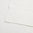 Close up of Tonic Living Positano Linen Shower Curtain showing tailored 4 inch bottom hem in creamy ivory linen.