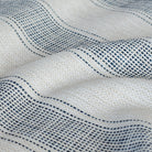 Revitalize Denim, a beige and navy blue striped outdoor fabric with dotted pattern from Tonic Living: close-up view.