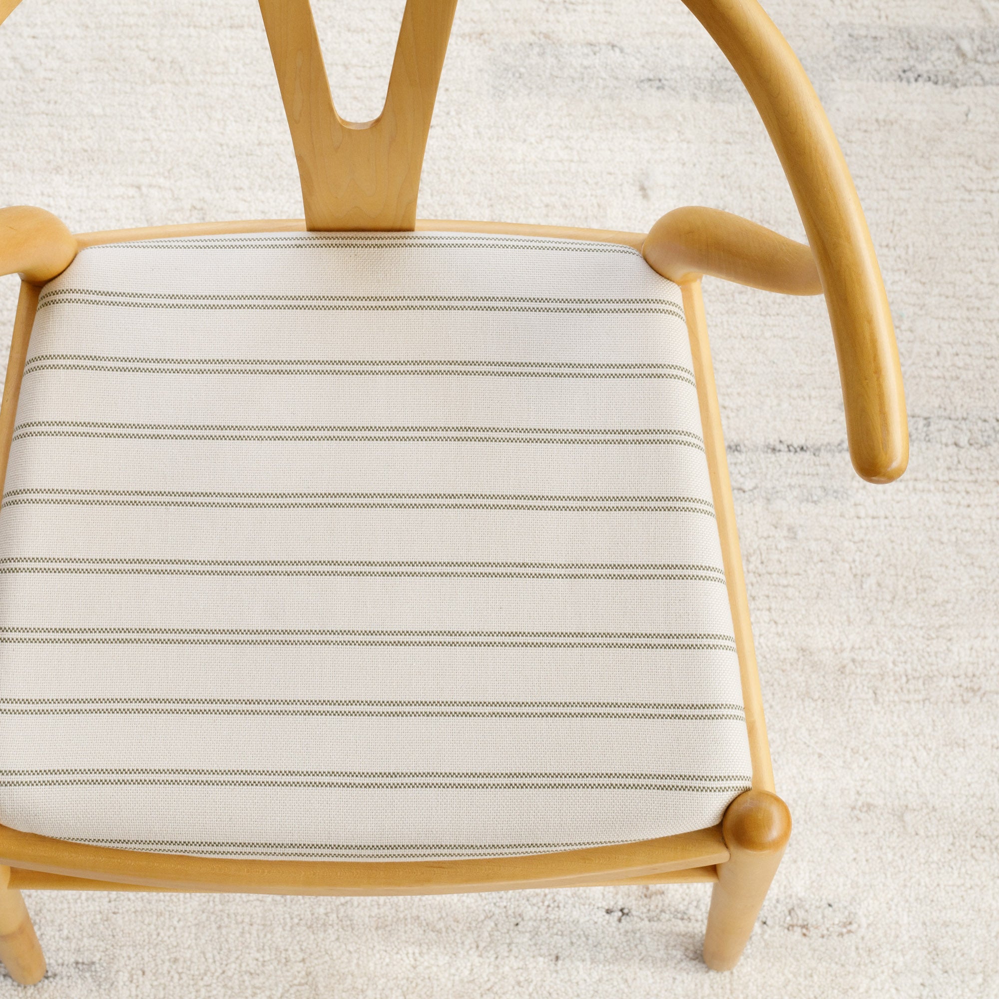 Dining chair upholstered in Tonic Living Rexton Stripe Fabric, Moss — durable high-performance upholstery fabric in moss green and oatmeal stripes.