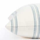 a white and chambray blue striped outdoor throw pillow : close up side view