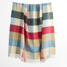 Tonic Living Rowan Check Wool Throw Blanket in Orchard, a colourful wool blanket with an oversized blue, red, green, and neutral check.