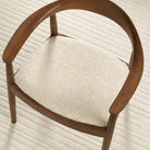 Tonic Living Rupert Parchment cream bouclé upholstery fabric shown on a dining chair seat.