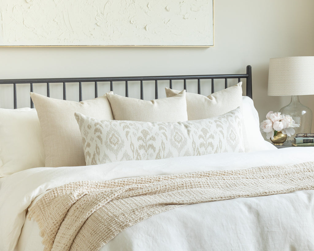 Sandy Neutral Bed Pillow Pairing: a combination of sandy cream throw pillows with a textured ikat bolster
