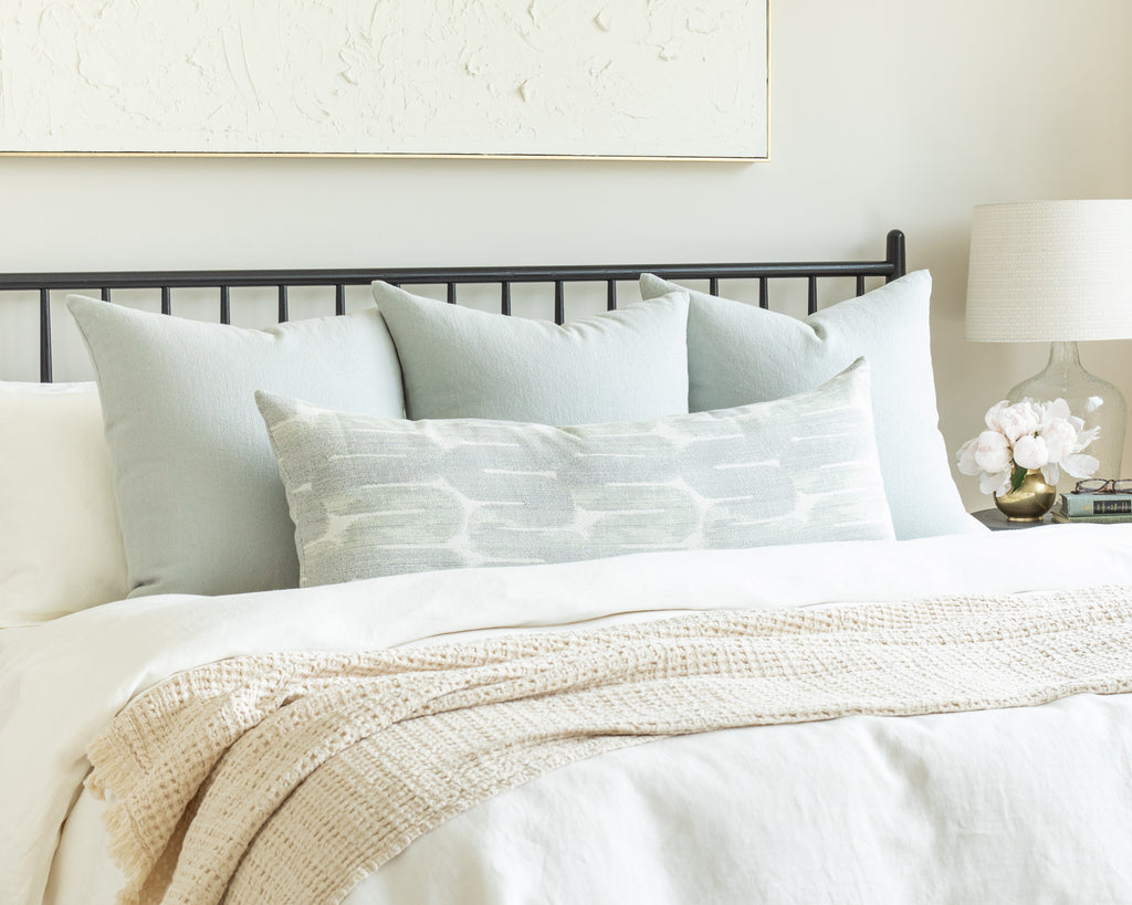Misty Blue Bed Pillow Pairing: a combination of watery blue solid throw pillows with a modern dynamic patterned bolster