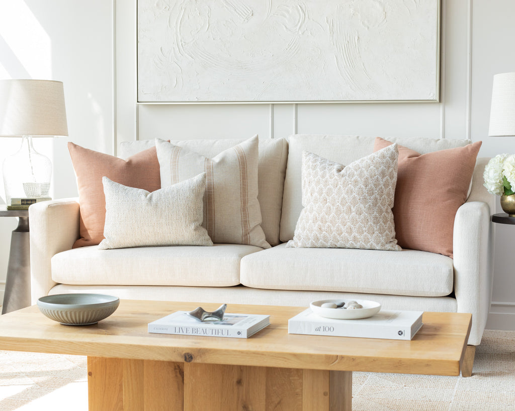 Terracotta and Oatmeal Sofa Pillow Pairing: a combination of earthy oatmeal and warm terracotta pillows mixing a classic farmhouse stripe with a small-scale organic pattern and solids